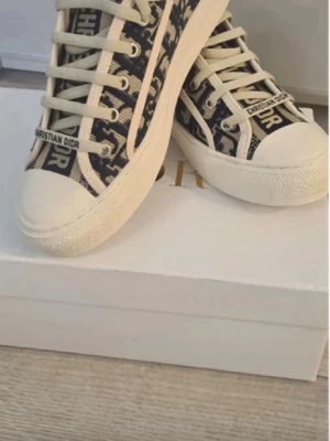 Dior skor  - Säljer ett par dior sneakers i storlek 37, helt i ny skick och ser exakt ut som på bilden. Säljer bara för de är för små för mig inga defekter. Hade kunnat sänka pris vid snabbt köp. Innersulan är 24,2 cm. Man får med dior sko lådan och äktighetsbevis! 