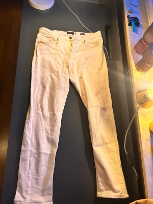 Beiga jeans från Massimo Dutti - Snygga vita jeans från Massimo Dutti med tapered fit. Klassisk femficksmodell med dragkedja och knapp i midjan. Tillverkade i ett mjukt bomullsmaterial som ger en skön känsla och stilren look. Perfekta för dig som vill ha ett par ljusa jeans med modern passform.