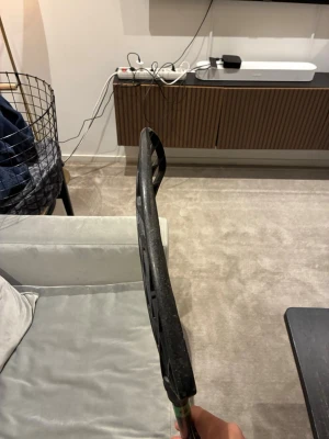 Svart innebandyklubba med grönt band - Säljer en svart innebandyklubba med ett grönt band på skaftet. Bladet har ett öppet, rutmönstrat design som ger bra bollkontroll och lätt vikt. Perfekt för dig som vill ha en smidig och modern klubba till träning eller match. Namnet på klubban är oxdog Ultimate light hes 27. Har lagt runt 3000kr på allt till denna klubba för nytt blad, och linda. Det är en right klubba så för vänsterhänta. Tror den är storlek 96cm