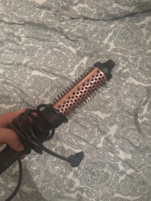 Rundborste med värme och sladd - Säljer en elektrisk rundborste i kopparfärg med svarta detaljer och borst runt hela cylindern. Perfekt för att styla håret och skapa volym. Borsten har ett svart handtag och lång sladd med vanlig stickkontakt. För mer bilder/justering av pris skriv gärna❤️🤗