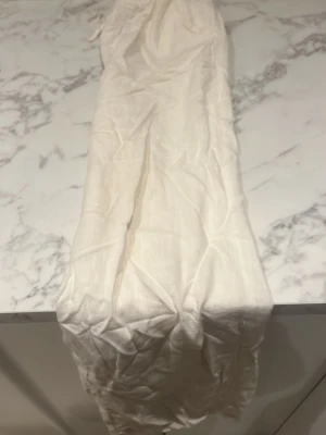 Vita vida linnebyxor med resårmidja - Säljer ett par vita linnebyxor med avslappnad passform och resår i midjan. Byxorna har en luftig och lätt känsla, perfekta för varma dagar. Materialet är linne och de har en enkel, stilren look. Passar dig som gillar en chill och clean stil.