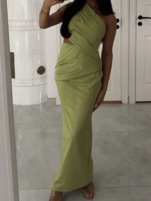 Oneshoulder ljusgrön klänning  - Snygg ljusgrön långklänning. Klänningen har ett ormakinn mönster som är super vacker. Klänning sitter tajt mot kroppen och skulle  säga att den är lite stretchig av sig, väldigt bekväm att ha på sig, då man kan röra sig fritt oavsett om det sitter tajt mot kroppen. Köpt för 640kr❣️☺️