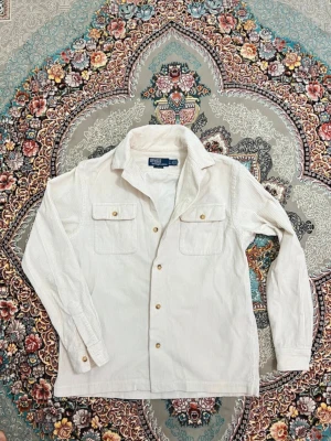 Ralph Lauren Overshirt, Manchester Vit/Creme  - Tja säljer nu min feta Overshirt från Ralph Lauren. Det är Vit/Creme färgad Manchester i storlek S och är perfekt nu till våren! Nypriset är ca 2500 och skicket är 8,5/10. Hör av dig vid minsta fundering👍 Priset är inte hugget i sten🤝