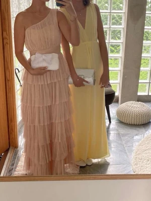 Ljusgul balklänning - Ljusgul balklänning, v-ringad med knyte i bak. Använd en gång. Vag fläck på höger sida, se sista bilden. Inget man tänker på. Skriv för mått eller om du har frågor☺️