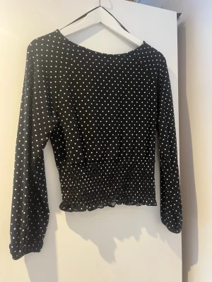Svart prickig blus med smock - Trendig svart blus med vita prickar och smockad midja. Den är ifrån Gina Young och i storlek 158/164