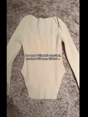 Ljus ribbad långärmad topp - Trendig ljus ribbad topp med lång ärm och snygg v-ringad skärning. Figurnära passform och stretchigt material som ger en smickrande siluett. Perfekt att styla med jeans eller kjol för en cool look.