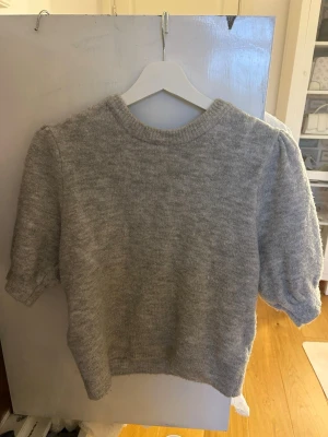 Grå stickad tröja med puffärm - Säljer denna fina gråa tröjan med trekvartsärm. Skriv till mig vid minsta fråga, pris kan diskuteras vid snabb affär.