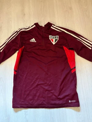 Sao Paulo-tröja halfzip M - En tunn långärmad träningströja från brasilianska fotbollslaget São Paulo. Använd ett fåtal gånger.