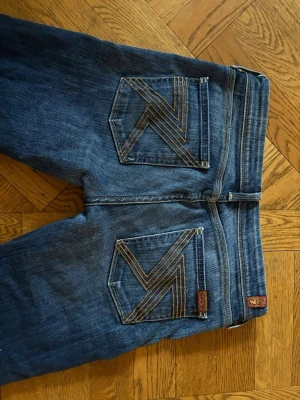 Blå bootcutjeans från 7 For All Mankind - Snygga blå bootcutjeans från 7 For All Mankind! Säljer för har liknande. Midjemåttet är 36 cm rakt över och innerbenslängden är 75 cm.