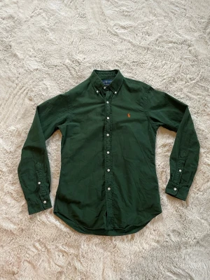 Grön skjorta från Ralph Lauren - Säljer den här mörkgröna Ralph Lauren skjortan. Använd runt 15 gånger, men säljer då den inte längre kommer till användning. Kontakta vid funderingar!!
