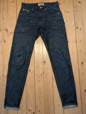 Naked and famous golden hour selvedge denim - LJUSARE I VERKLIGHETEN. Nästintill oanvända. Max 10-20 användningar och har aldrig tvättats. Gjorda på 12oz Japansk selvedge denim. W29L32. Modellen är slim/straight beroende på vikt. Easy Guy heter passformen