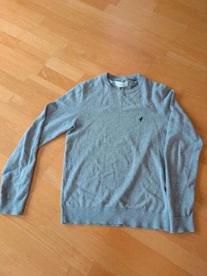 Grå stickad tröja från Pier One - Säljer en grå tröja från Pier one med rund halsringning. En otroligt snygg stickad tröja i storleken XS. Tvättlappen är avklippt men det påverkar ju inte användningen.