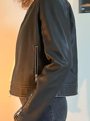 Urtvättad svart skinnjacka - Säljer min helt oanvända skinnjacka (fuskskinn) från ONLY. Den är superfin! Men kommer inte till användning.   Storlek S. Mått finns på sista bilden. Jag är 162cm.  Originalpris 729kr