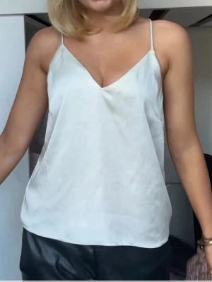 Vit silkeslen linnetopp - Säljer en vit linnetopp med tunna axelband och v-ringning.