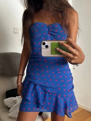 Blå prickig kort klänning mango  - Snygg blå axelbandslös kort klänning med röda prickar och volangdetaljer. 💙💙