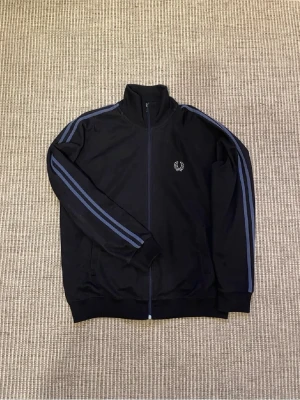 Fred Perry Tröja - En fräsch Fred Perry tracktop/zipup som jag nu säljer pga storlek. Nypris ligger runt 900-1200kr. Skulle säga att den är lite mindre än L. 