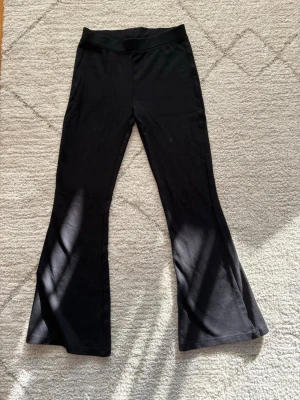 Svarta utsvängda leggings - Snygga svarta leggings med utsvängda ben och hög midja. Tillverkade i mjukt stretchigt material som sitter skönt på kroppen.