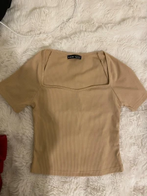 Tshirt / topp - Ribbad beige topp. Inga defekter. Åtsittande.