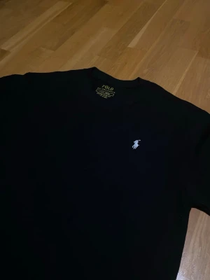 Svart Ralph Lauren Tshirt - Säljer en helt ny svart Ralph lauren tröja för endast 249kr! Har bara prövas men aldrig blivit använd. Vid frågor eller intresse så tveka inte på att kontakta mig! Passformen är slim 