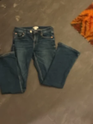 Mörkblå jeans från Gina Tricot - Snygga mörkblå jeans från Gina Tricot med klassisk femficksmodell och raka ben. Jeansen har kontrastsömmar och är tillverkade i denim med en skön passform. Perfekta för dig som gillar en tidlös stil.