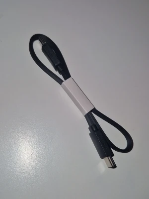 USB C kabel - En svart USB-C till USB-C kabel med platt design som gör den smidig att ta med sig. Perfekt för laddning och dataöverföring mellan kompatibla enheter. 