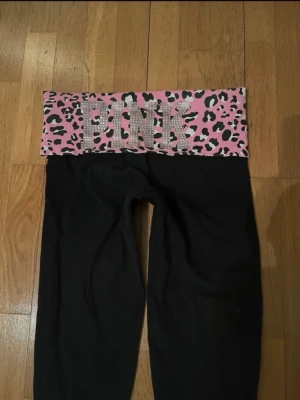 Lowrise Fold over leggings - Supersnygga och unika lågmidjade VS PINK Fold over leggings! Dessa är i mycket bra skick, lite av printet är sprucket och någon diamant kan vara borta men inget mer att anmärka på!😇🙌 Perfekta att sy om till utsvängda eller klippa till shorts? 💖 Dessa är unika o säljs inte längre, därav priset.