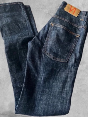 Mörkblå jeans från Nudie Jeans - Säljer nu ett par mörkblåa jeans från nudie jeans! Storlek: W26 L32