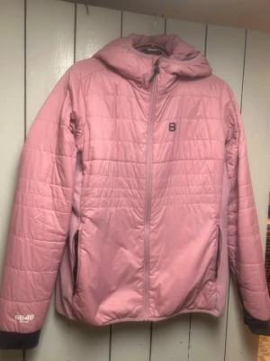 Rosa pufferjacka från 8848 Altitude - Säljer en rosa pufferjacka från 8848 Altitude med huva och hel dragkedja framtill. Jackan har två sidofickor med dragkedja och diskret logga på bröstet samt ärmen. Perfekt för kalla dagar och riktigt skön passform.
