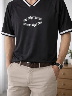 Svart oversized t-shirt H&M XS - Svart oversized t-shirt från H&M med vit text 'togetherness' i gotisk stil på bröstet. V-ringad med breda, ribbade muddar i svart och vitt vid hals och ärmslut. Tillverkad i luftig polyester, perfekt för en chill och sportig vibe.