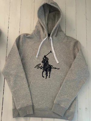 Ralph Lauren hoodie herr, storlek S  - Hej! Säljer denna riktigt schyssta hoodie från Ralph Lauren. Den är i storlek M men sitter en storlek litet och passar därför som en S. Den är endast använd någon enstaka gång och är därmed i ett nyskick. Original lappar och påse finns kvar och medföljer naturligtvis vid köp. Jag fraktar alltid snabbt! Mvh