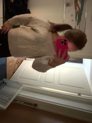 Beige kabelstickad tröja - Mysig beige kabelstickad tröja med bred rund halsringning och långa, lite pösiga ärmar. Tröjan har ett klassiskt stickat mönster och är perfekt för lager på lager under kyliga dagar. Passar till både jeans och kjol för en avslappnad look.