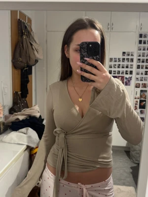 Gina tricot topp - Super fin beige omlottopp med lång ärm och knyt i midjan. Den är från Gina tricot och är i storlek xs!💕