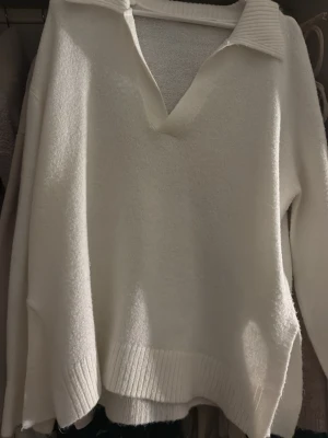 Vit stickad tröja med krage - Klassisk vit stickad tröja med bred krage och v-ringning. Och är ifrån lager 157. Den är verkligen jätte fin men har inte kommit till användning och bara ligger där i min garderob. Man kan skapa fina outfits med denna tröjan. Och den är strl XS men jag upplever att den är lite större i storleken