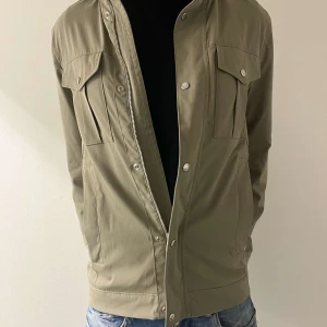 J.Lindberg field jacket - Tja säljer denna field jackan ifrån j.lindeberg i storlek S men passar även M. Den är i nyskick och bara använd ett fåtal gånger. Perfekt till våren. Har inbyggd luva. Nypris 3599kr mitt pris 1200kr. DESTO SNABBARE AFFÄR DESTO BÄTTRE PRIS 