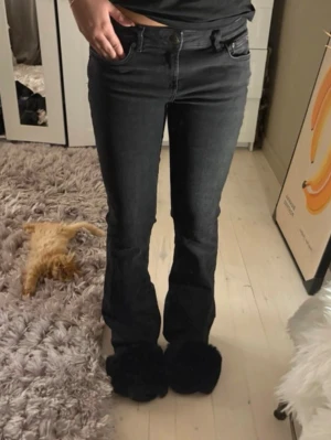 Svarta bootcut jeans - Snygga svarta bootcut jeans med klassisk femficksmodell och normal midja. Jeansen har en lätt utsvängd passform nedtill och är tillverkade i ett stretchigt denimtyg som sitter bekvämt. Perfekta till sneakers eller boots för en cool look.
