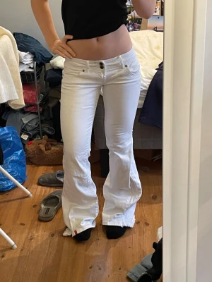 Lågmidjade vita jeans - Säljer dessa vita jeans som är utsydda till bootcut. Midjemått 36 cm och innerbenslängd 80 cm. 