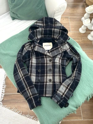 Rutig skepparkavaj  - En vintage skepparkavaj från Abercrombie i barnstorlek XL, motsvarar en vanlig XS. Finns 1 lös knapp som håller luva, funkar dock hur fint som helst. Jag fraktar inom 24h, frakt med PostNord prioriteras.