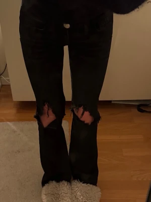 Svarta slitna jeans med hål - Säljer ett par svarta jeans med hål vid knäna. Dom är från Gina Young i storlek 152 men passar mig som har xxs-xs oftast i byxor🩵midjemåttet rakt över är 34cm