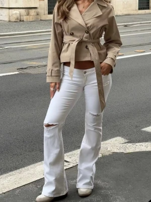 Vita bootcut jeans med slitningar - Säljer ett par vita bootcut jeans med trendiga slitningar vid knäna, från Gina Tricot. Perfekta för en cool och avslappnad look. SLUTSÅLDA ONLINE