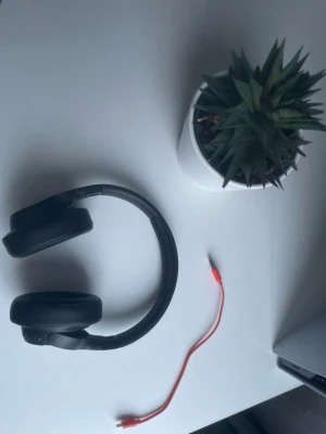 JBL hörlurar - Snygga svarta JBL hörlurar med mjuka, vadderade kåpor och justerbart huvudband. Kommer med en röd USB-laddningskabel. Perfekta för musik, gaming eller videos. Modern design i plast och konstläder. Väldigt bra kvalite på ljudet och bra batteri tid. Pris kan diskuteras 