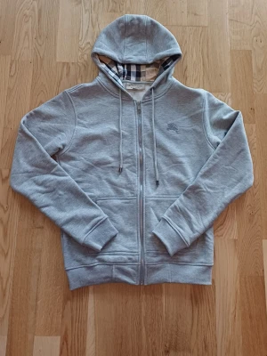Grå Burberry Hoodie - Hej, här säljer jag min oanvända grå Burberry hoodie eftersom det ej passar mig. Priset kan diskuteras. Storlek S