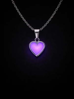 Halsband med rosa hjärthänge - Snyggt halsband i rostfritt stål med ett hjärthänge i rosa emalj som dessutom lyser i mörkret med ett lila sken. Perfekt för dig som gillar unika detaljer och vill sticka ut lite extra. Kedjan är tunn och smidig, och hjärtat har en modern, stilren design. Kedjans längd är 45 cm + 5 cm förlängningskedja. Vanligt dagsljus en kort stund räcker för att hänget ska ändra färg i mörker. Tål vatten och missfärgas inte. Lång livslängd.