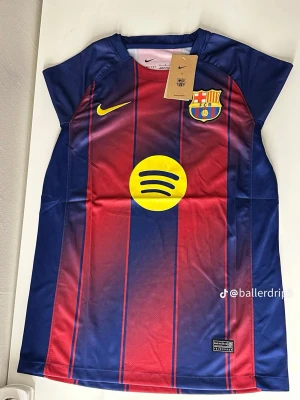 Barcelona matchtröja Nike blå/röd - Stilren och högkvalitativ fotbollströja inspirerad av FC Barcelonas klassiska design. Tröjan är tillverkad i ett bekvämt och ventilerande material som passar både för träning och vardagsbruk. Storlekar: S, M, L Skick: Ny
