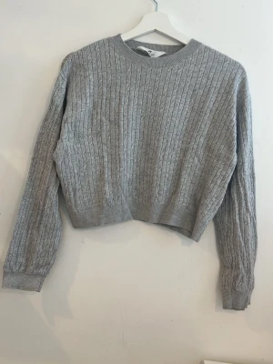 Grått ribbat set med tröja & byxor - Säljer ett mysigt grått set med ribbad struktur, består av en långärmad tröja med rund hals och matchande byxor med raka ben. Perfekt för dig som gillar en avslappnad och stilren look. Materialet känns mjukt och stretchigt, troligen en bomulls- eller viskosmix.