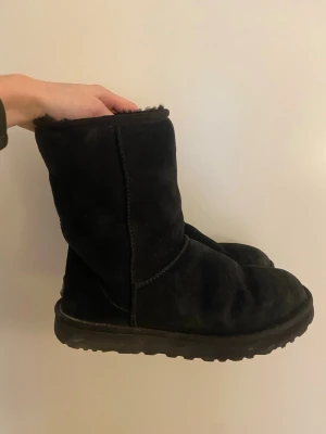 UGGs 41 - Äkta UGGS  med hög skaft och mjukt foder. Tillverkade i mocka med fårskinn på insidan och grov sula för extra komfort. Perfekta för kalla dagar och ger en avslappnad vibe till din outfit. Använda men kan piffas upp med svart impregneringsspray. 