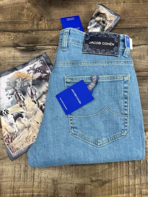 Ljusblå jeans från Jacob Cohën - Snygga ljusblå jeans från Jacob Cohën med klassisk femficksmodell och raka ben. Jeansen har exklusiva detaljer som märkets logotyp på bakfickan och patch bak i midjan. Tillverkade i mjuk denim med kontrastsömmar och silverfärgade knappar.