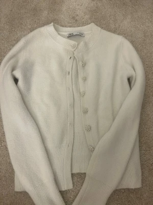Vit kofta från Zara - Snygg vit stickad kofta från Zara med fina knappar. Passar till de mesta