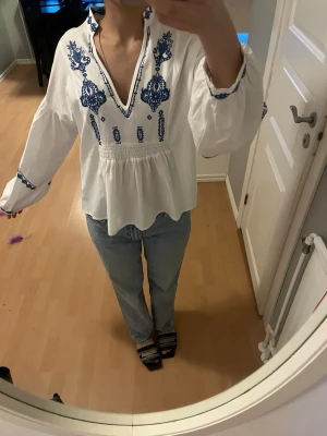 Somrig Blus  - Otroligt fin vit blus med blåa detaljer, säljer då den aldrig användes💗 Köpt på Indiska, Nypris:750kr
