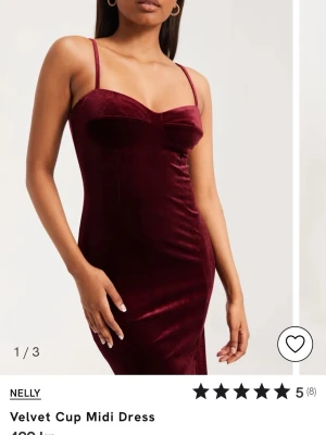 Vinröd sammetsklänning från Nelly - Snygg vinröd sammetsklänning från Nelly med smala axelband. Klänningen har markerade kupor och en elegant, enkel design som ger en lyxig känsla. Perfekt för dig som vill sticka ut med en klassisk men trendig look. Storleken är en L men passar M likaså