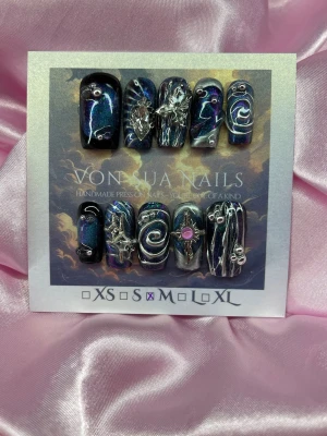 DarkNova (M);Medium Square;Curved - Unika handgjorda press-on naglar i svart bas med skimrande cateye blå och lila toner. Dekorerade med 3D silverdetaljer, swirl-mönster, pärlor och metalliska stjärnor. Mixade former och coola effekter för en edgy look.M: 16 mm, 12 mm, 12,5 mm, 11,5 mm, 10 mm